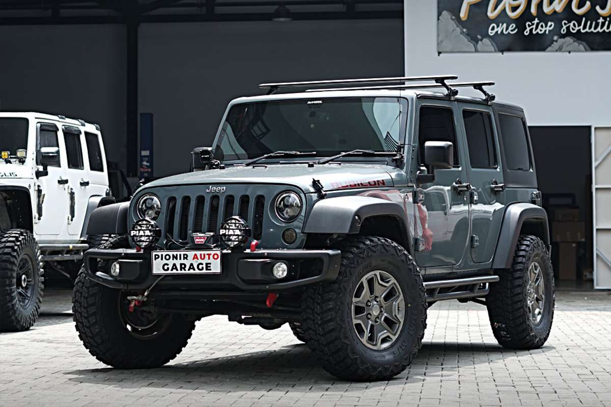 Modifikasi Jeep JK di Pionir Auto Garage dengan lift kit TeraFlex, shock Falcon, ban Delium 35”, lampu PIAA, dan roof bar.