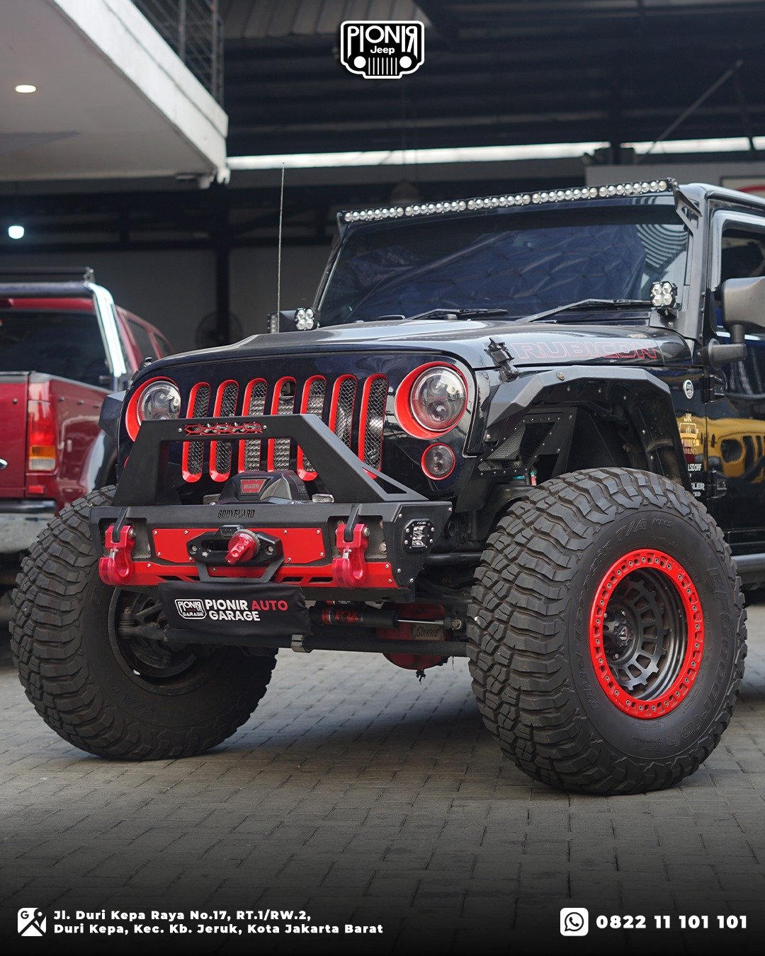 Tampilan depan Jeep JK nuansa merah hitam gagah di bengkel Pionir Auto Garage