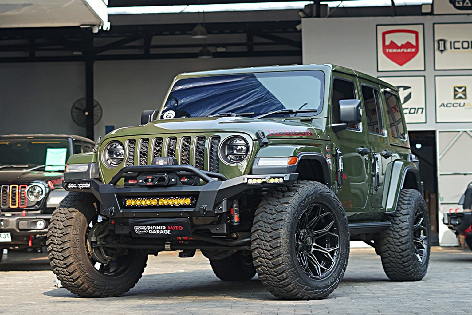 Modifikasi Jeep Rubicon JL Green Army milik Angga Roy garapan Pionir Jeep dengan bemper ADD Offroad, velg 4Play R20, dan lampu Baja Designs